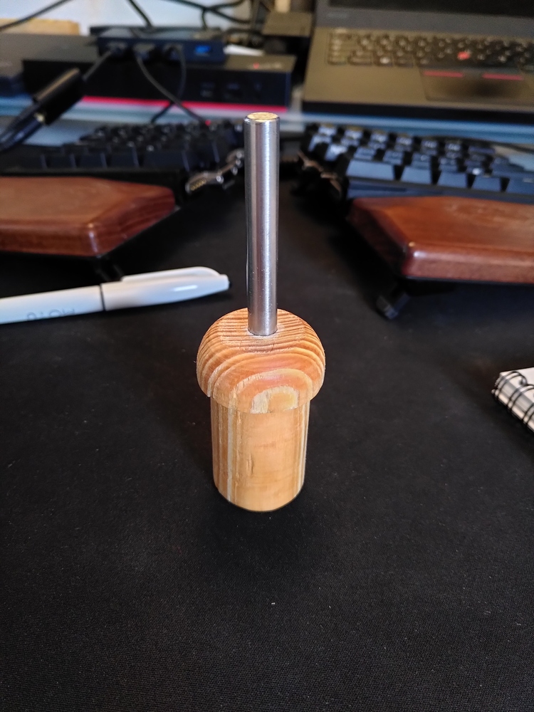 A wooden end cap for the poles. It has a stainless steel pin in the top.