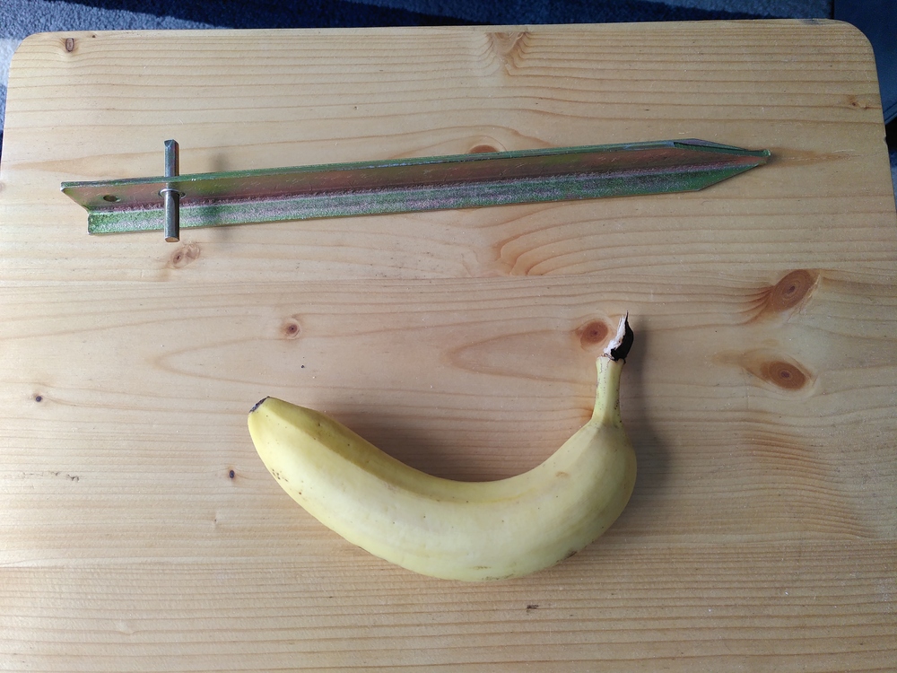 a 30cm long T-shaped steel tent peg. A banana is added for scale.